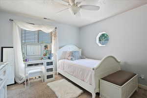 Bedroom with carpet flooring, a ceiling fan, and a textured ceiling