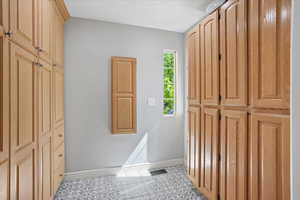 Hallway with baseboards and light tile patterned flooring