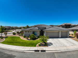 Prairie-style house with an attached garage, a front yard, concrete driveway, and a tiled roof
