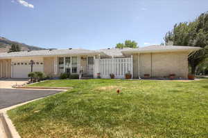 Ranch-style house featuring brick siding, concrete driveway, a garage, and a front & side yard