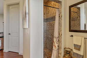 Full bath with a shower stall and wood finished floors