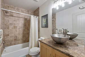 Full bathroom featuring vanity and shower / bath combination with curtain