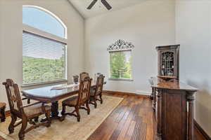 Dining area featuring high vaulted ceiling, a ceiling fan, and hardwood / wood-style flooring