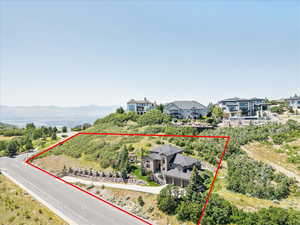 Aerial view of residential area featuring property boundaries highlighted and mountains