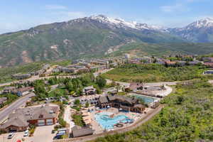 Aerial perspective of suburban area featuring a pool and a mountainous background
