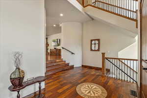 Stairway with hardwood / wood-style floors, recessed lighting, and a high ceiling