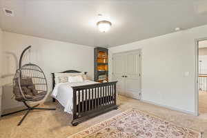 Carpeted bedroom with baseboards and a closet