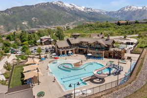 Community pool with a mountain view, a patio, a water slide, and a residential view