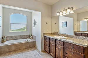 Bathroom with a bath, vanity, plenty of natural light, and tile patterned flooring