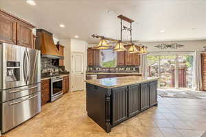 Kitchen with stainless steel appliances, custom exhaust hood, plenty of natural light, tasteful backsplash, and recessed lighting