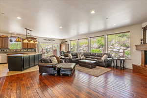 Living room featuring wood-type flooring, a high end fireplace, and recessed lighting