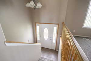 Tiled foyer with a chandelier and a high ceiling