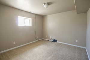 Carpeted empty room with baseboards