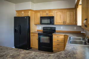 Kitchen with black appliances and dark countertops