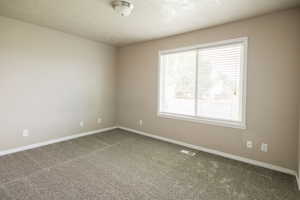 Empty room featuring carpet floors and baseboards