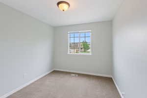 Carpeted empty room with baseboards
