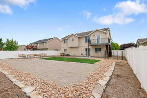 Rear view of house featuring stucco siding, a residential view, a fenced backyard, a patio, and a balcony