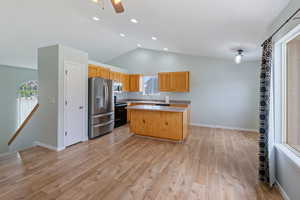 Kitchen featuring appliances with stainless steel finishes, light countertops, a center island, light wood-style floors, and recessed lighting