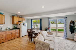Kitchen with freestanding refrigerator, light wood-style floors, recessed lighting, open floor plan, and stone countertops