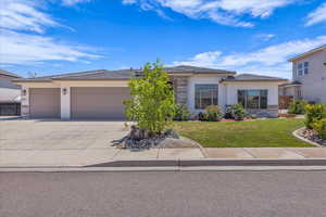 Prairie-style home featuring an attached garage, driveway, stucco siding, and a front yard