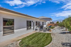 Rear view of house with a patio, stucco siding, and a mountain view