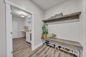 Mudroom with light wood-style floors and independent washer and dryer