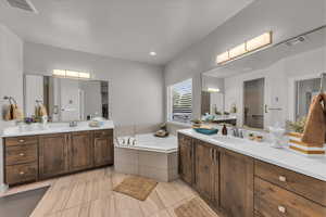 Full bath featuring two vanities and a garden tub