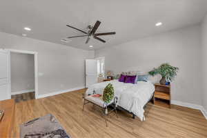 Bedroom with light wood-type flooring, recessed lighting, and a ceiling fan