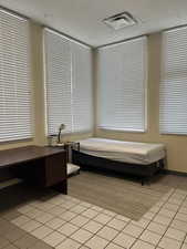 Bedroom featuring a paneled ceiling and light tile patterned floors
