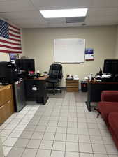 Office with a paneled ceiling and light tile patterned floors