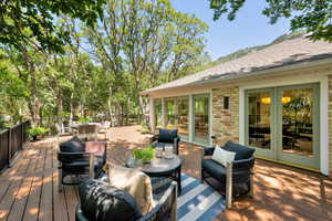 Wooden terrace with outdoor dining space, an outdoor living space, and french doors
