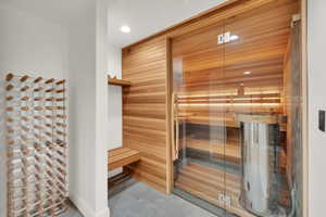 Relaxing sauna with recessed lighting and concrete flooring
