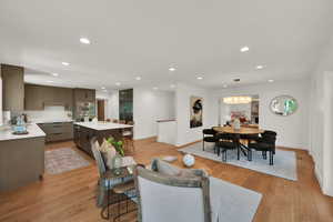 Living room featuring recessed lighting, light wood-style flooring, and a chandelier