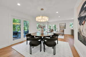 Dining room featuring recessed lighting, light wood-style flooring, a chandelier, and french doors