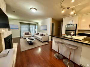 (virtually staged) Living area with dark wood-type flooring and a tile fireplace