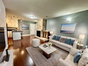 (virtually staged) Living room with dark wood-type flooring and a large fireplace