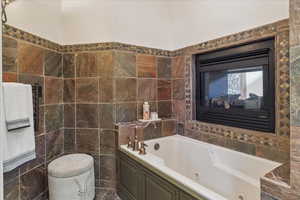 Full bathroom featuring tile walls and a whirlpool tub