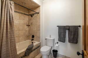 Full bathroom featuring shower / bath combo and toilet