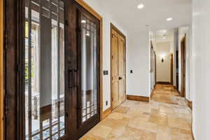 Hallway with stone tile floors and recessed lighting