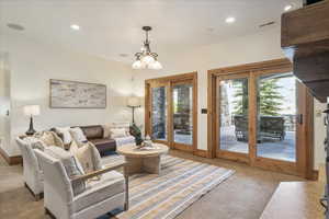 Carpeted living room featuring recessed lighting and a chandelier