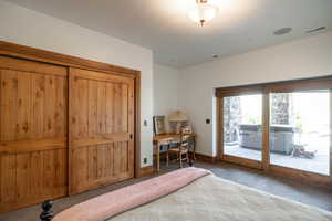 Carpeted bedroom with access to outside and a desk