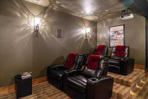 Home theater room with wood finished floors and baseboards