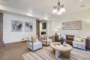 Carpeted living area featuring recessed lighting and a chandelier