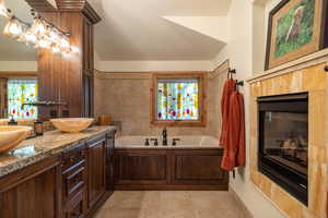 Bathroom featuring a bath, double vanity, and tile patterned floors