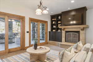 Carpeted living area with a premium fireplace, recessed lighting, and a chandelier