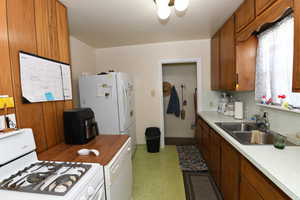 Kitchen featuring white appliances and brown cabinetry