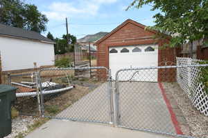 Detached garage with a gate and driveway