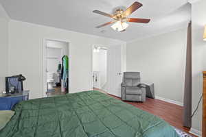 Bedroom featuring ornamental molding, wood finished floors, ceiling fan, and ensuite bathroom