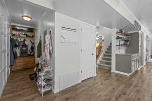 Foyer featuring ornamental molding, wood finished floors, stairs, and a textured ceiling