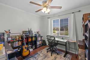 Office space featuring wood finished floors, a ceiling fan, and ornamental molding